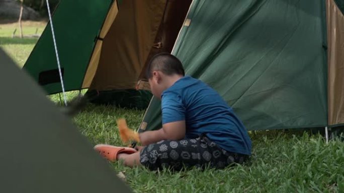 夏天露营的小男孩。孩子正在搭帐篷。