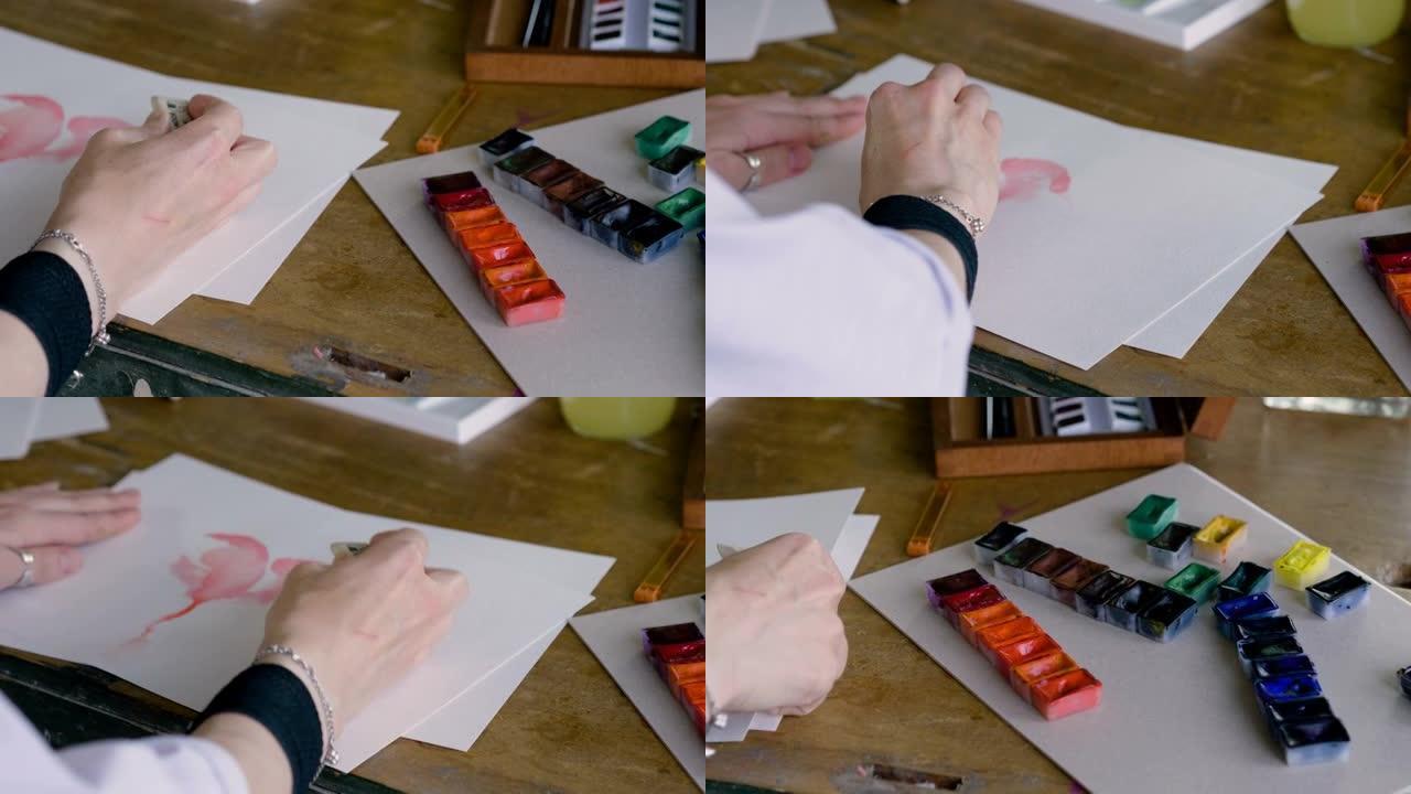 女艺术家的手用画笔用水彩画了一颗红色的心。4K