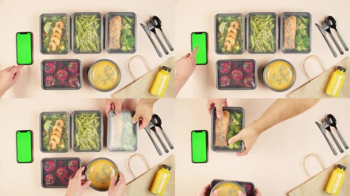 送餐俯视图，用一次性容器带走餐点。午餐盒配有煮熟的素食菜肴，使用带色度绿屏的手机。健康饮食。餐饮服务