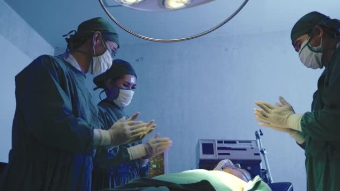 一组外科医生戴着无菌手套和防护口罩，成功后受到病人的热烈掌声