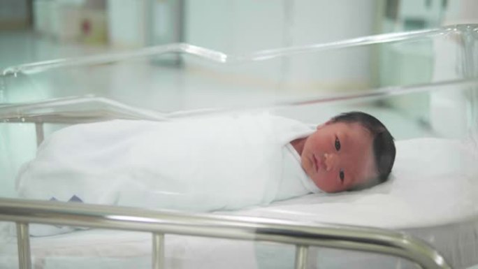 亚洲可爱的新生婴儿，快乐，微笑，躺在医院的床上。
