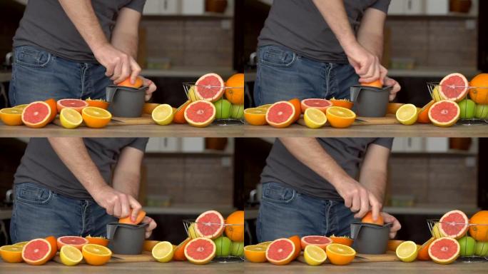 一名男子正在用柑橘榨汁机榨取橙汁。手部特写，橘子，榨汁机，健康生活方式
