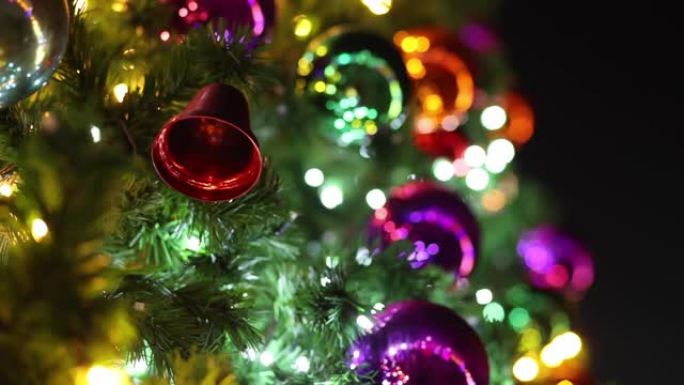 圣诞树树枝上的圣诞铃铛以模糊的圣诞彩球为背景