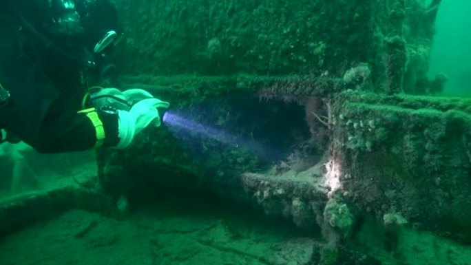 水肺潜水员探索沉船消防箱