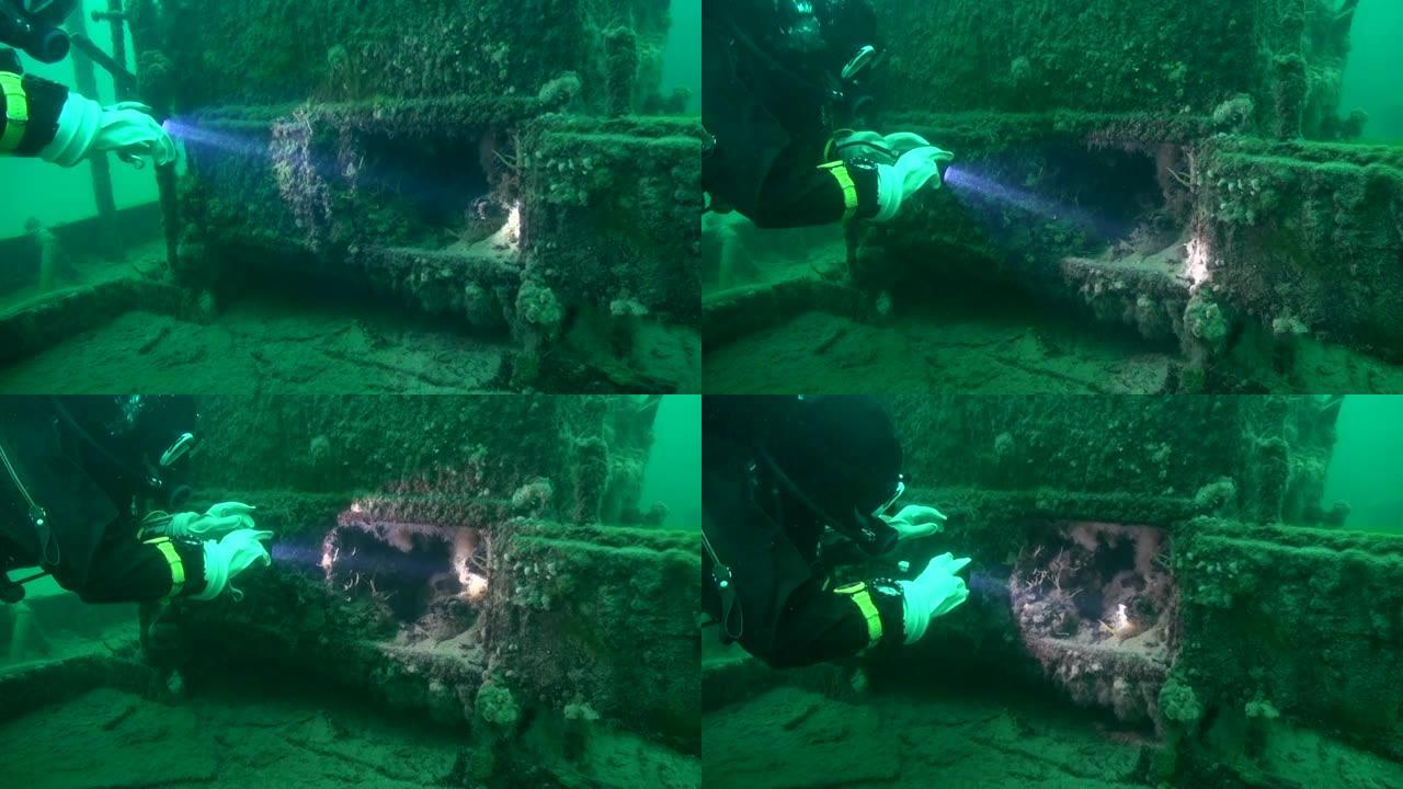 水肺潜水员探索沉船消防箱