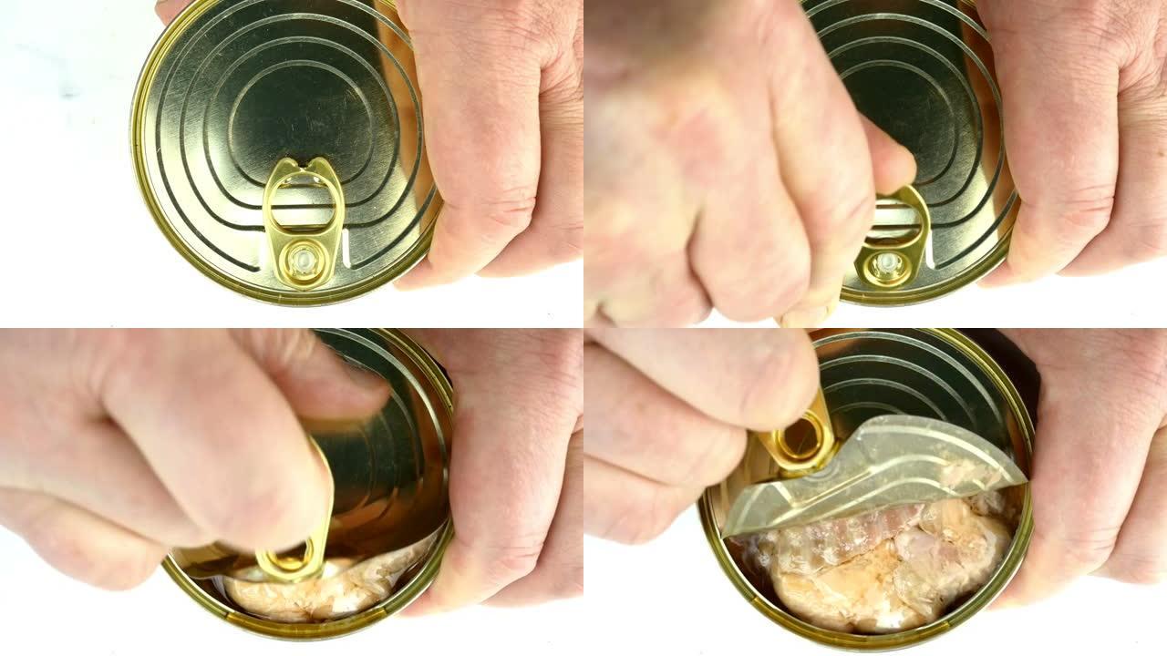 用手打开白色酱汁罐装三文鱼罐头的金属罐头。提起金属盖。