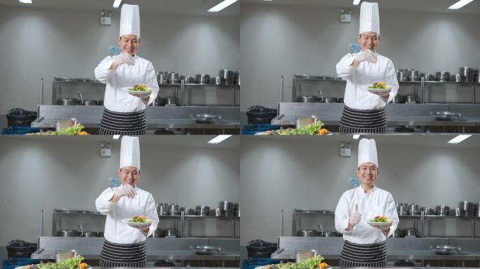亚洲男厨师在餐厅厨房工作，向相机展示一盘食物