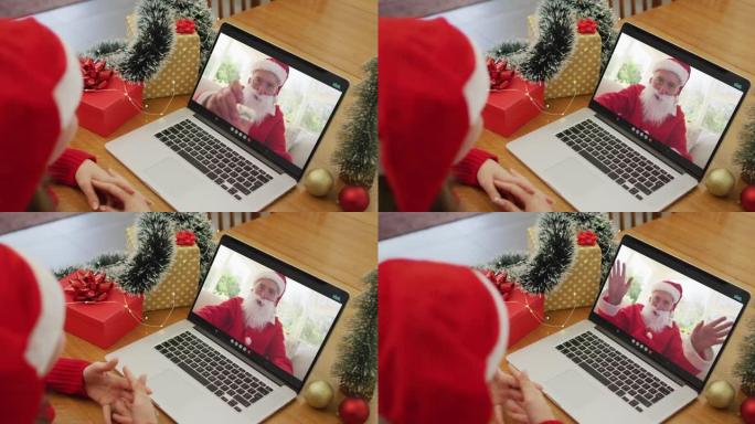 圣诞节时，白人妇女在笔记本电脑上与圣诞老人进行视频通话
