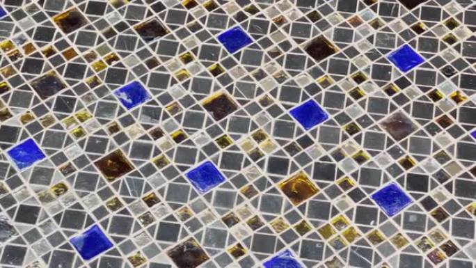 抽象视频美丽的多色马赛克作为地板覆盖物，光在光泽涂层上的反射，蓝色，白色和琥珀色的元素