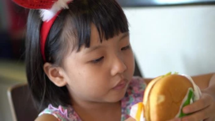 中国女孩与圣诞鹿发带吃汉堡