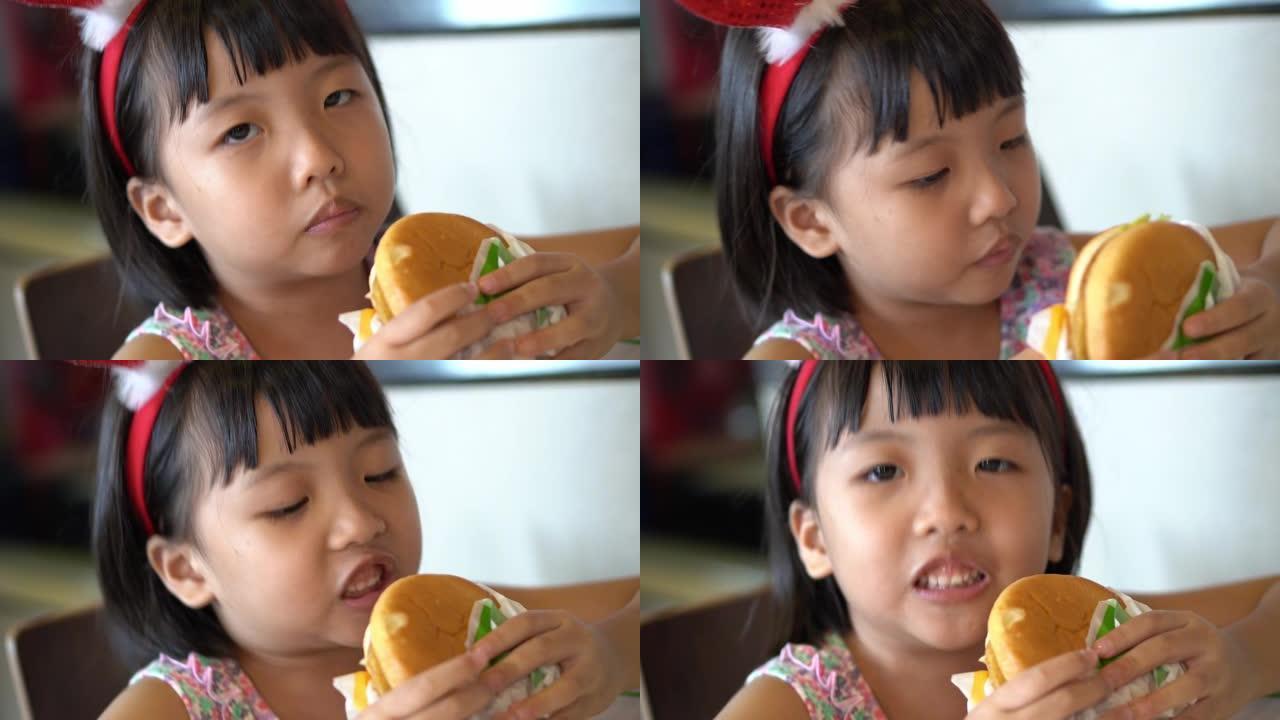 中国女孩与圣诞鹿发带吃汉堡
