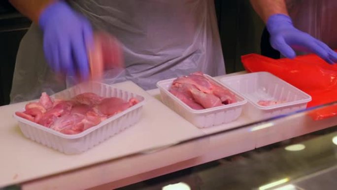 超市肉区的卖家把鸡肉放在塑料盒里