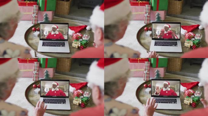 高级高加索夫妇使用笔记本电脑与屏幕上的快乐圣诞老人进行圣诞节视频通话