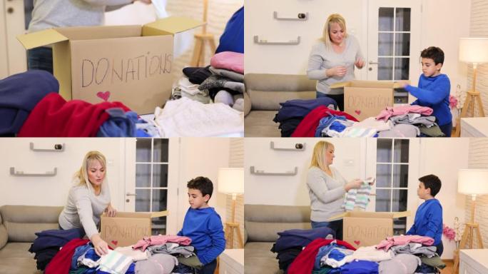 可爱的母亲和儿子一起打包旧的可收回的衣服捐赠给有需要的人