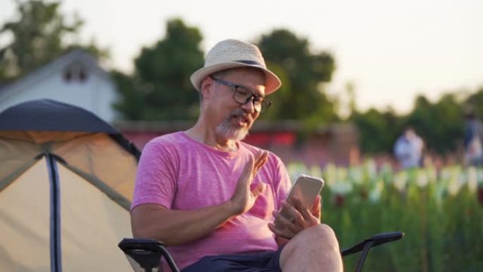 中年男子通过坐在花园里的电话访问在线约会网站，专注于手