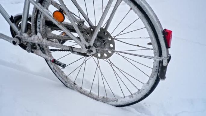 在寒冷的冬季，意外的强降雪暴风雪中，城市自行车被积雪和结块的冰冻雪泥覆盖