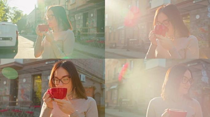轻松微笑满意的女人，红色的咖啡站在街边享受阳光明媚的一天