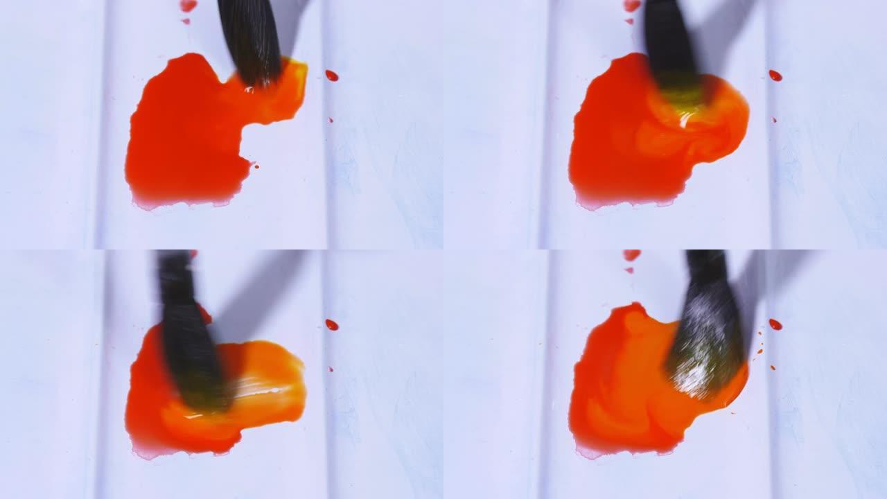 艺术家用画笔将水彩颜料混合在调色板中。