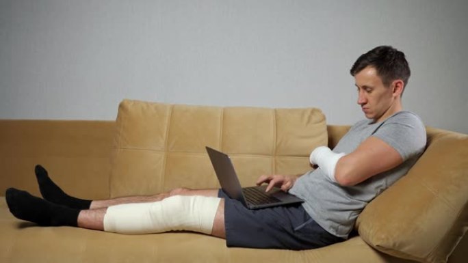 膝盖和前臂受损的男子通过笔记本电脑远距离工作