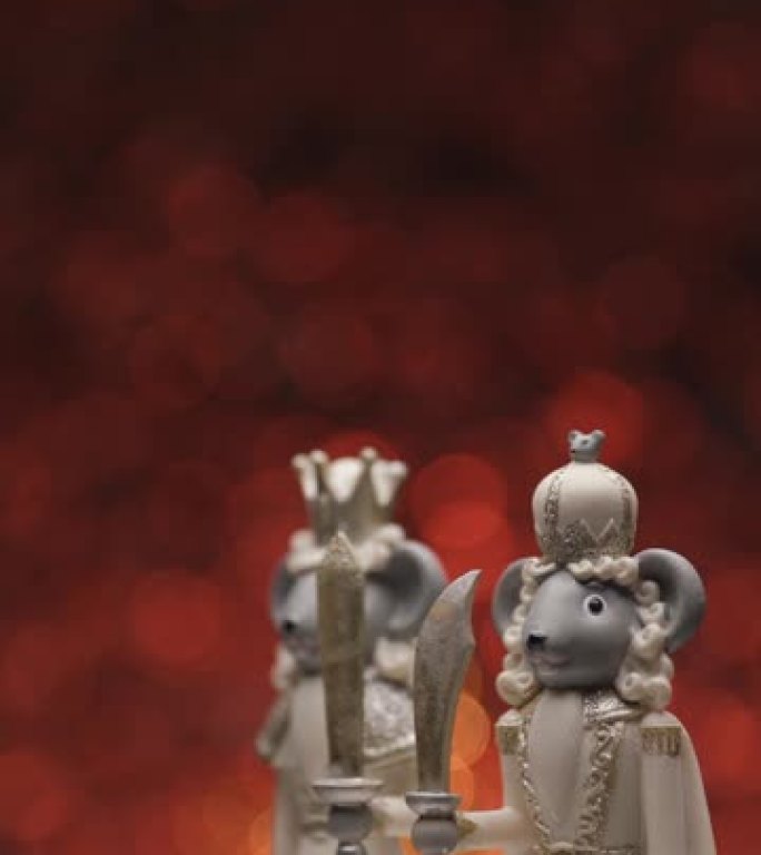 可爱的优雅圣诞小雕像，两只皇家鼠标手持剑，在bokeh红色灯光背景前旋转