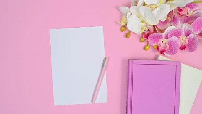 写作白皮书和浪漫的鲜花和书籍出现在柔和的粉红色主题上。停止运动动画