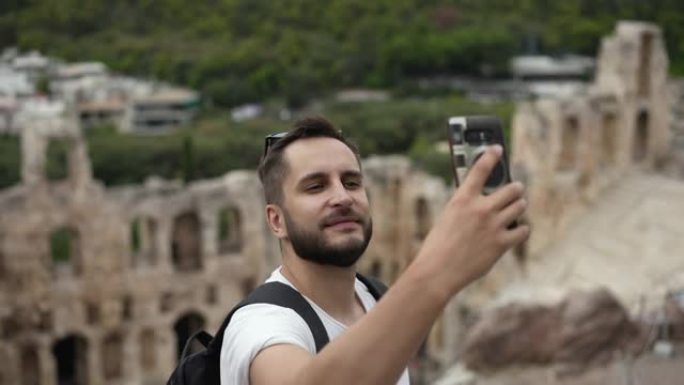 旅游男子在雅典卫城山上自拍。古代遗迹的图片