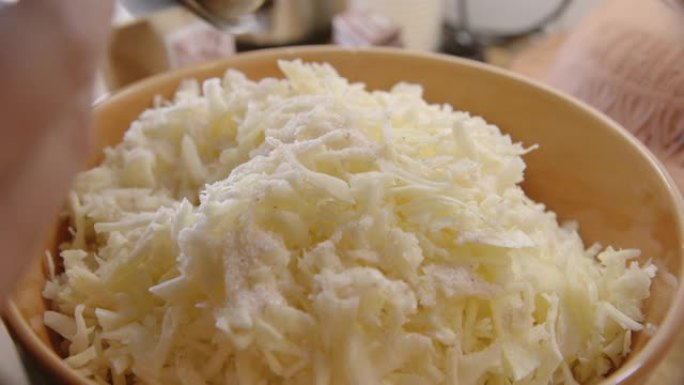 酸菜-用量匙将盐倒在切碎的白菜上，关闭