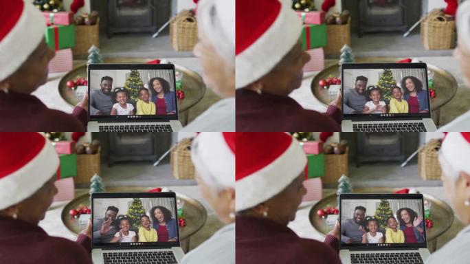 多元化的高级女性朋友使用笔记本电脑进行圣诞节视频通话，屏幕上有微笑的家人