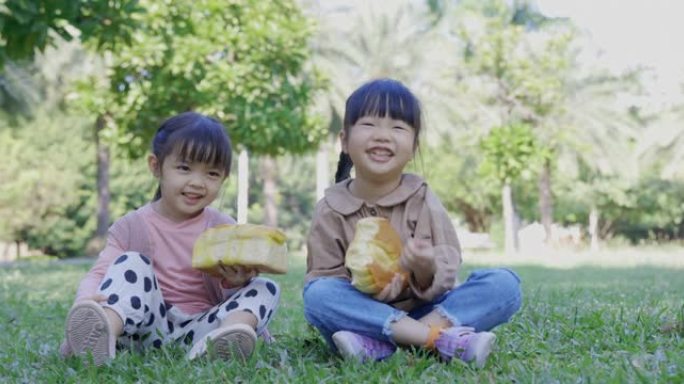 在公园野餐，孩子们吃面包