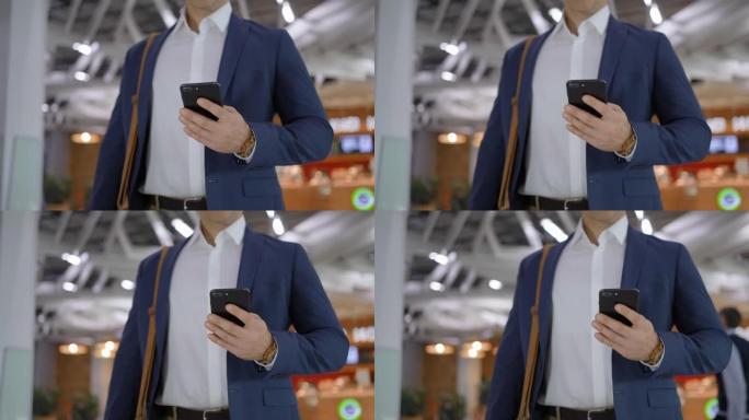 在购物中心或办公室大厅使用智能手机的商人男性手的特写镜头，社交网络商务人士键入sms消息。穿着夹克的