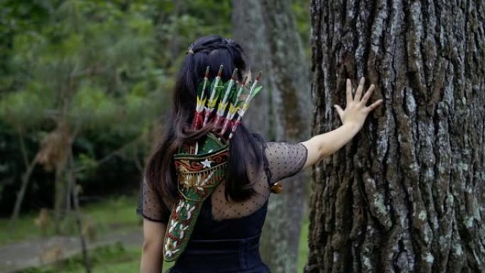 一个女人用手触摸大树