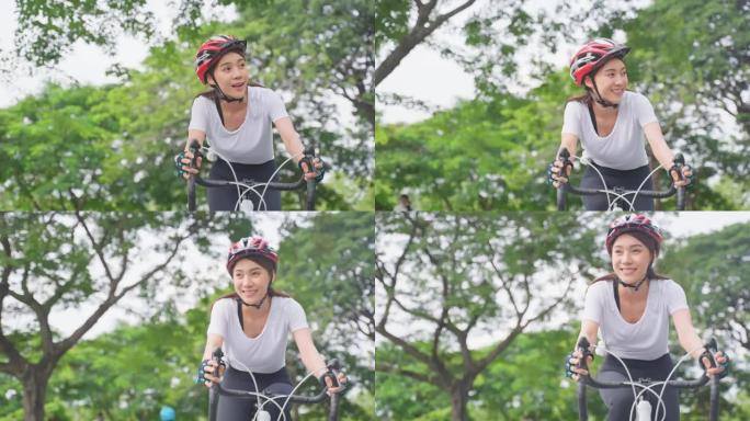 亚洲年轻美女骑自行车在公园健康。穿着运动服的活跃运动员运动女孩感到新鲜和放松，晚上通过骑自行车锻炼来