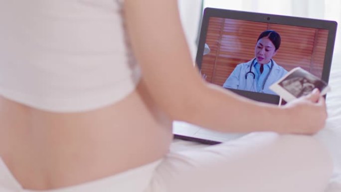 孕妇在线视频电话会议，在家与医生会面和咨询。病毒大流行期间的远程保健。孕妇与产科医生交谈，计划和检查