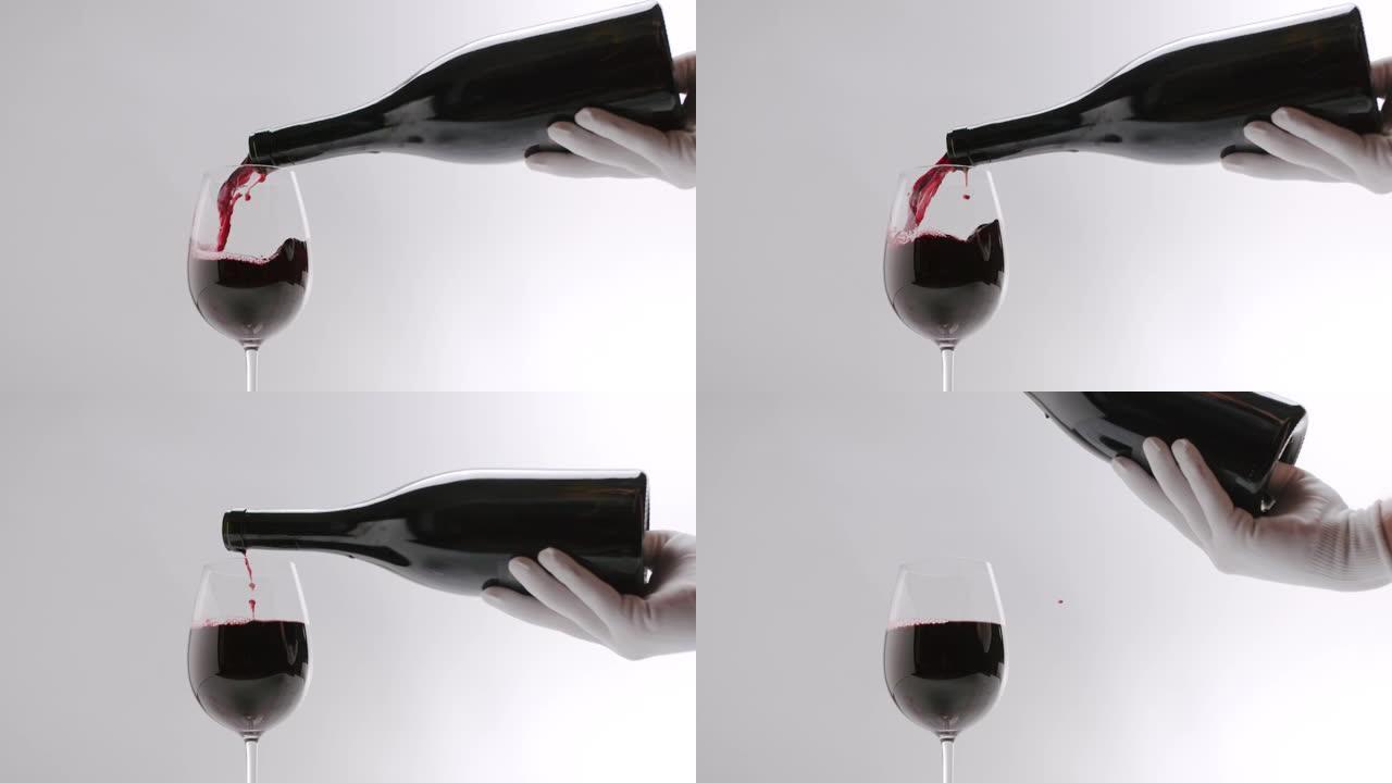 慢动作将红酒倒入白色背景的透明玻璃杯中