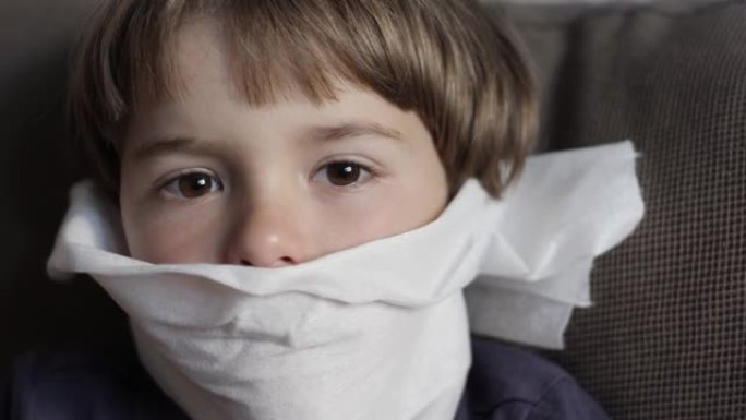 不快乐的生病的孩子正在流鼻涕、打喷嚏和擤鼻涕。儿童感冒流感疾病。不健康的生病男孩的肖像与餐巾关闭她的