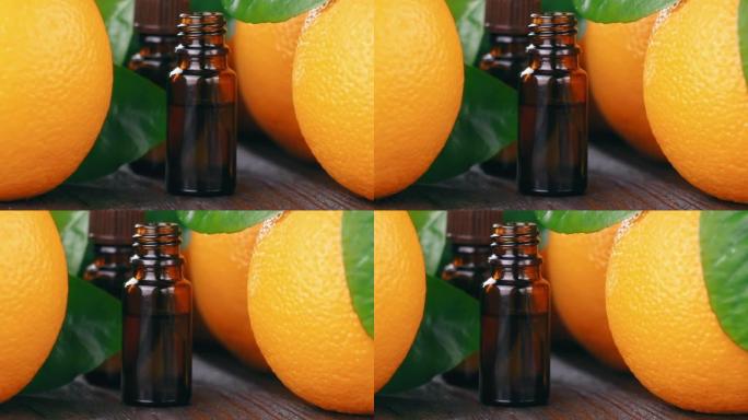 玻璃瓶中的天然有机橙色精油。带有绿色叶子的新鲜橙色水果。健康的素食。维生素食品。成熟的橙子。
