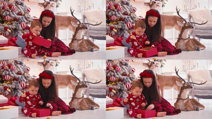 两个可爱的小孩吃圣诞糖果的4k视频肖像。在孩子们手中制作巧克力手工糖果。兄弟在圣诞树附近吃糖果