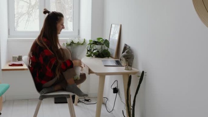 女人待在家里，用笔记本电脑进行视频通话