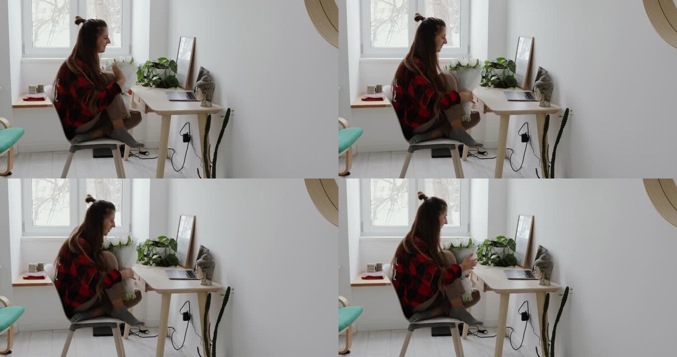 女人待在家里，用笔记本电脑进行视频通话