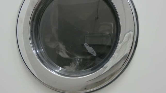 黑白衣服。衣物在洗衣店的白色洗衣机中洗涤。