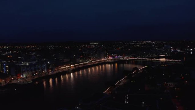 城市照明桥梁和滨水区的空中全景。水面反射灯。香农河平静地在夜镇流淌。爱尔兰利默里克