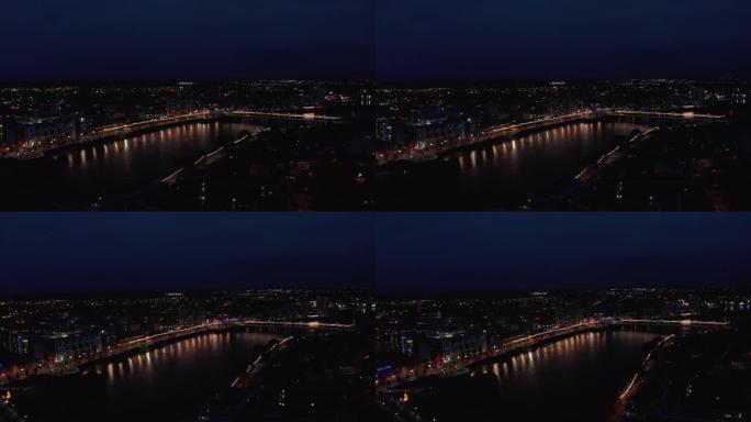 城市照明桥梁和滨水区的空中全景。水面反射灯。香农河平静地在夜镇流淌。爱尔兰利默里克