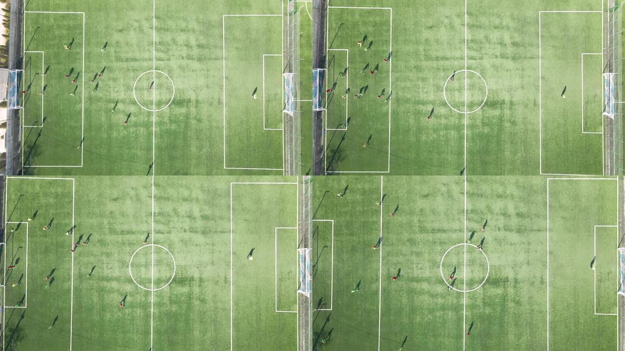 在绿色体育馆踢足球的足球运动员的鸟瞰图