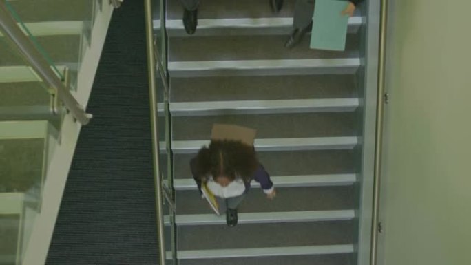 英国青少年学生在学校楼梯下移动