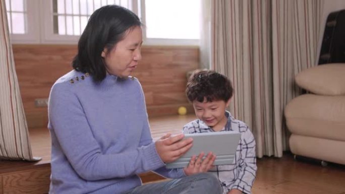 母子俩在客厅用iPad玩游戏