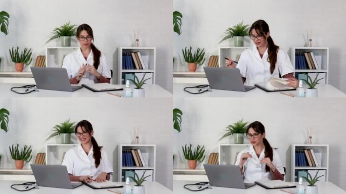 年轻女医生坐在办公室里，通过笔记本电脑视频电话接受媒体关于健康状况的在线采访。女医护人员在医院通过网