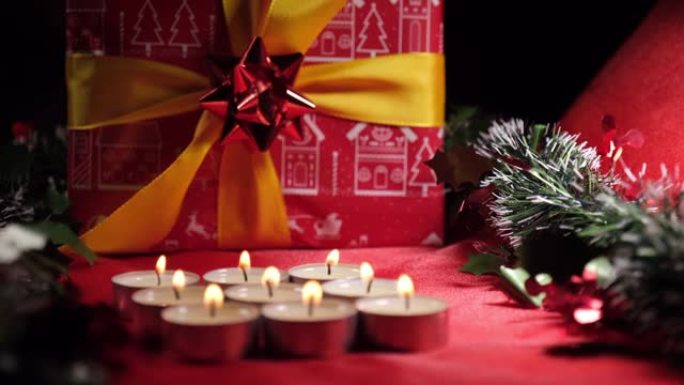 圣诞蜡烛和礼物装饰。红色背景上的蜡烛灯。寒假庆典