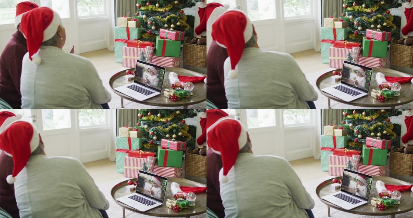 多元化的资深女性朋友使用笔记本电脑进行圣诞节视频通话，屏幕上有微笑的男孩