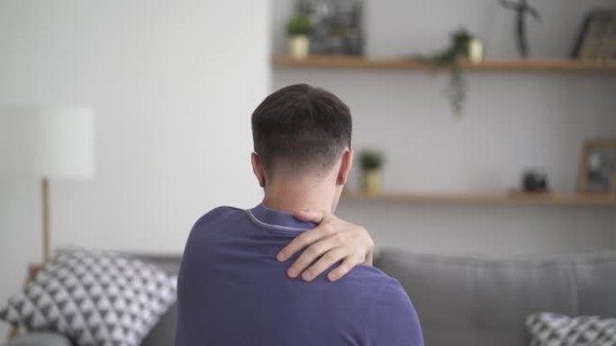 男人在家做肩膀和脖子的自我按摩