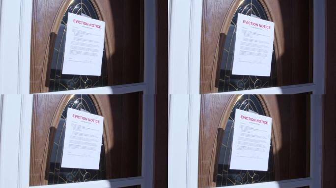 手持照片，将纸质驱逐通知贴在郊区居民区出租房屋的木制前门上